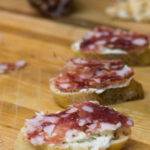 Crostini with herbed cream cheese and salami