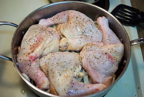 Add chicken and season for Baked Chicken Leg Quarters with Caramelized Onions.