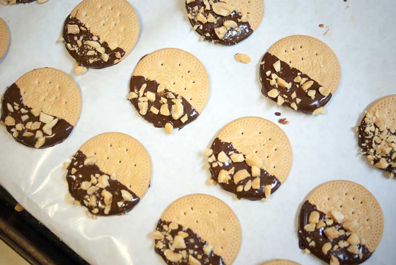 chocolate dipped cookies cooling on paper