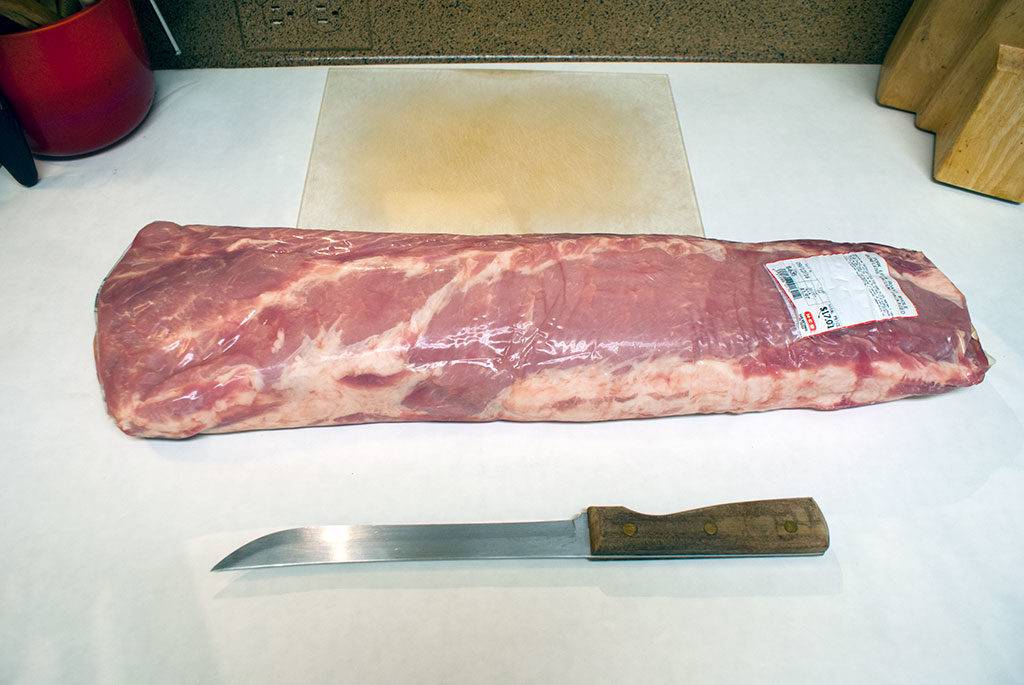 A whole pork loin looks pretty daunting laid out on the board, but butchering it yourself will save a ton of money, and it's not as hard as it seems