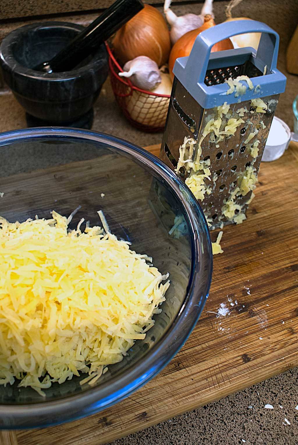 Grate potatoes for Crispy Parmesan Hash Browns