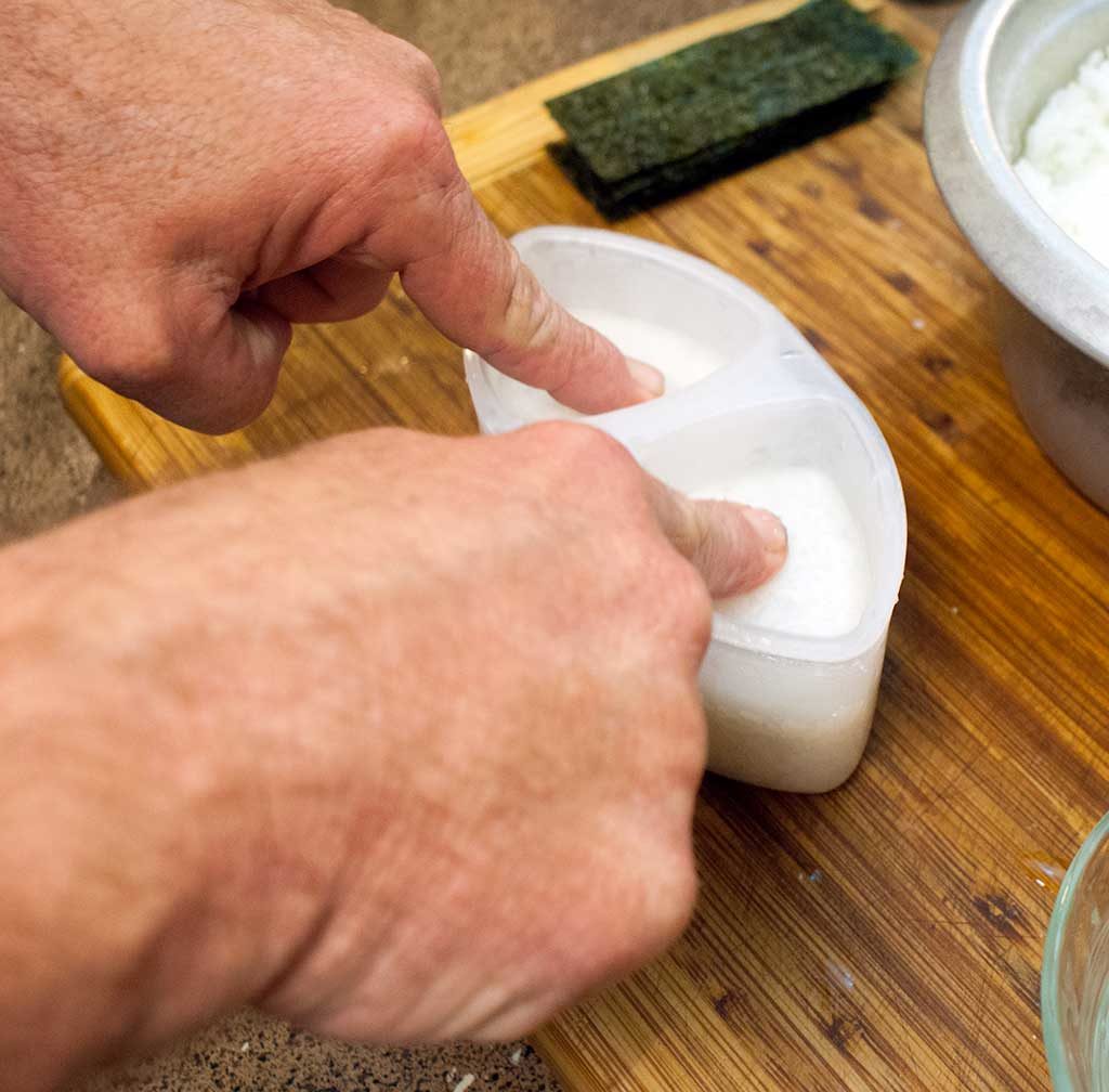 finishing onigiri in a press