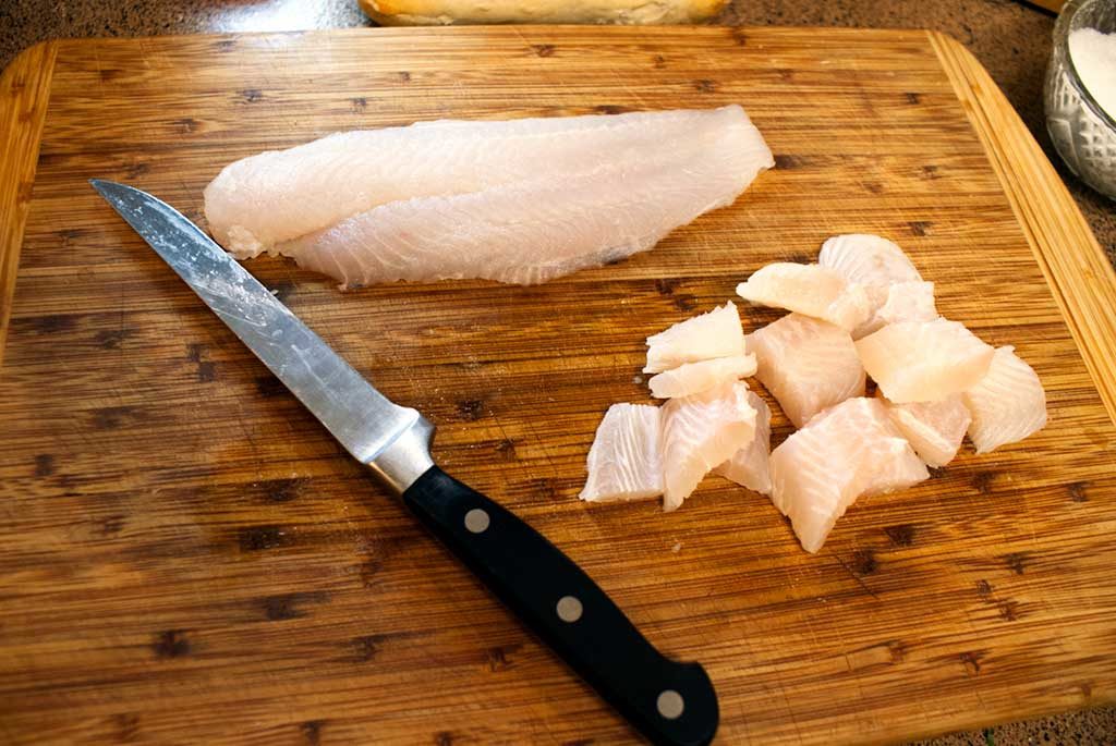 Cut whitefish (In this case, it's swai fillets) into cubes, if desired. Or you could just poach the fillets whole.