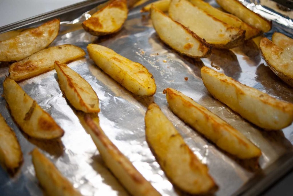 Roasted potato wedges on cookie sheet