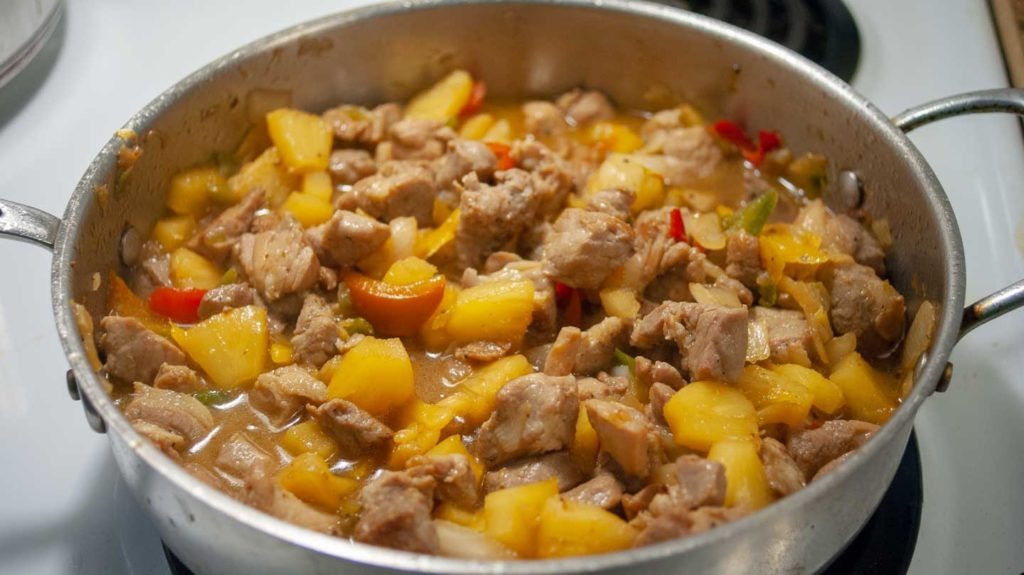 Pour soy and pineapple juice mix over pork and pineapple in pan