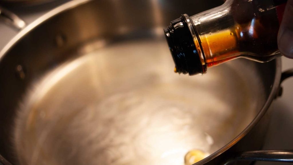Adding a dash of sesame oil to a hot pan