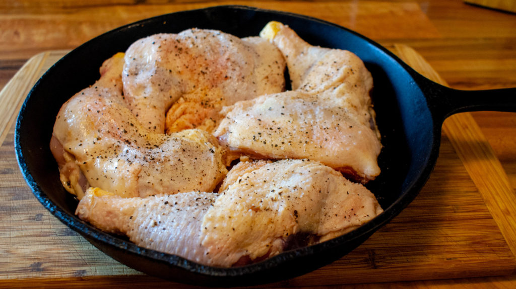 Chicken leg quarters in a cast iron skillet