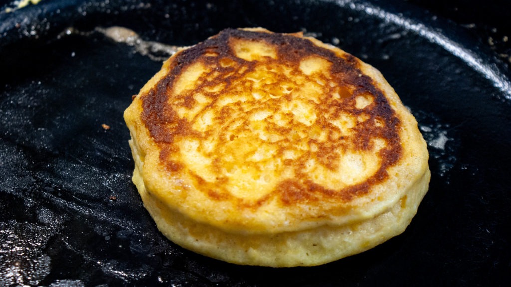 Hoecake cooking in a cast iron skillet