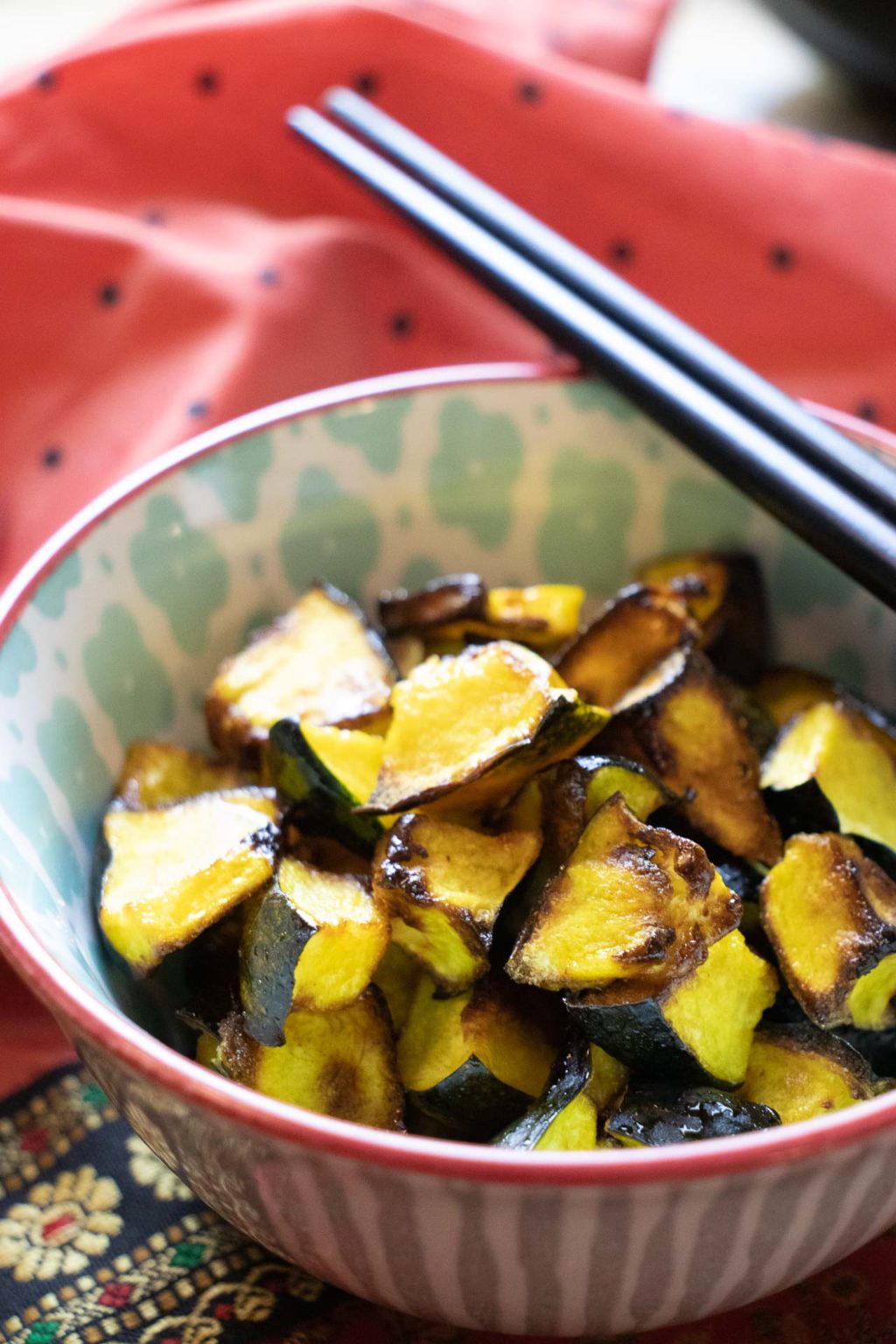 Honey glazzed roasted acorn squash cubes in bowl with chopsticks