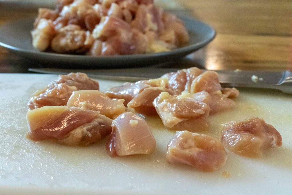 diced raw chicken on a cutting board