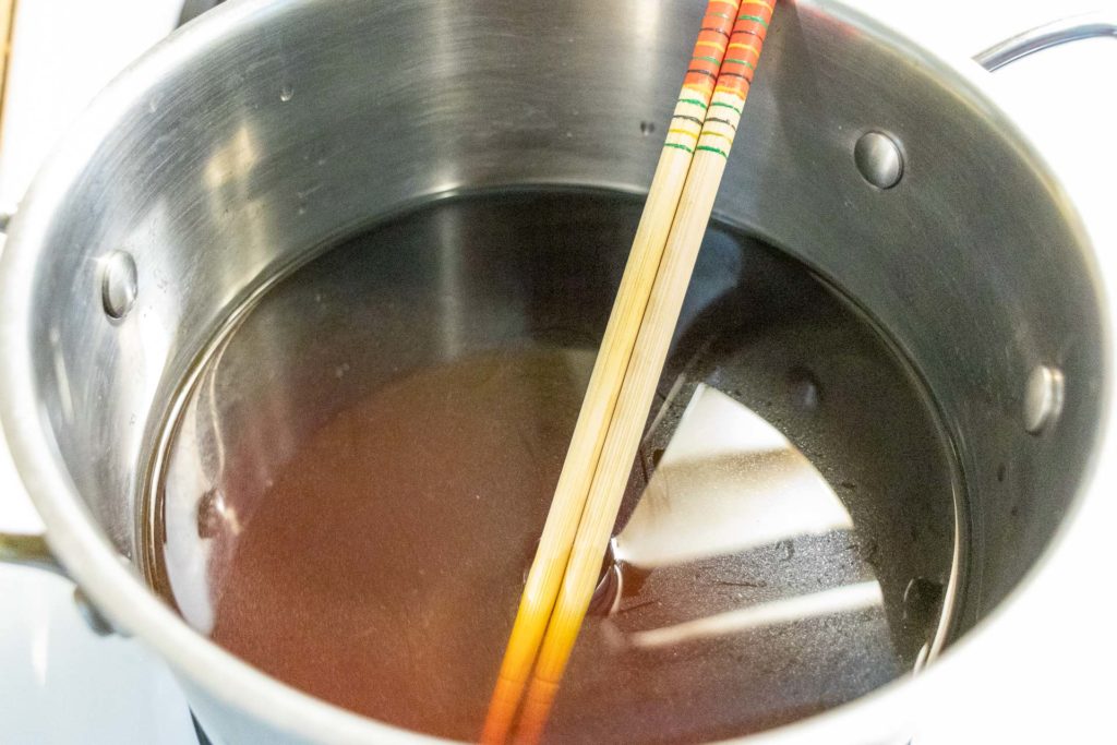 Stock in a pot with chopsticks 