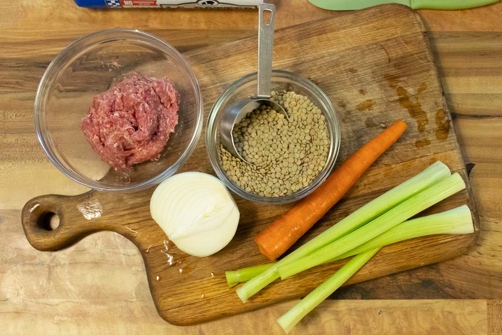 Lentil soup ingredients laid out on chopping board