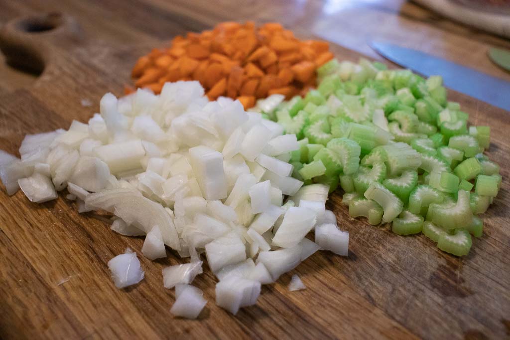 chopped carrots celery and onion on cutting board