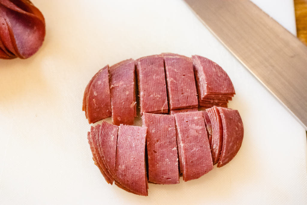 Dried beef sliced into squares on a cutting board