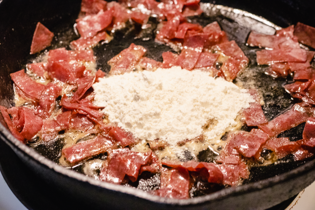 Dried beef and flour in a hot skillet with butter